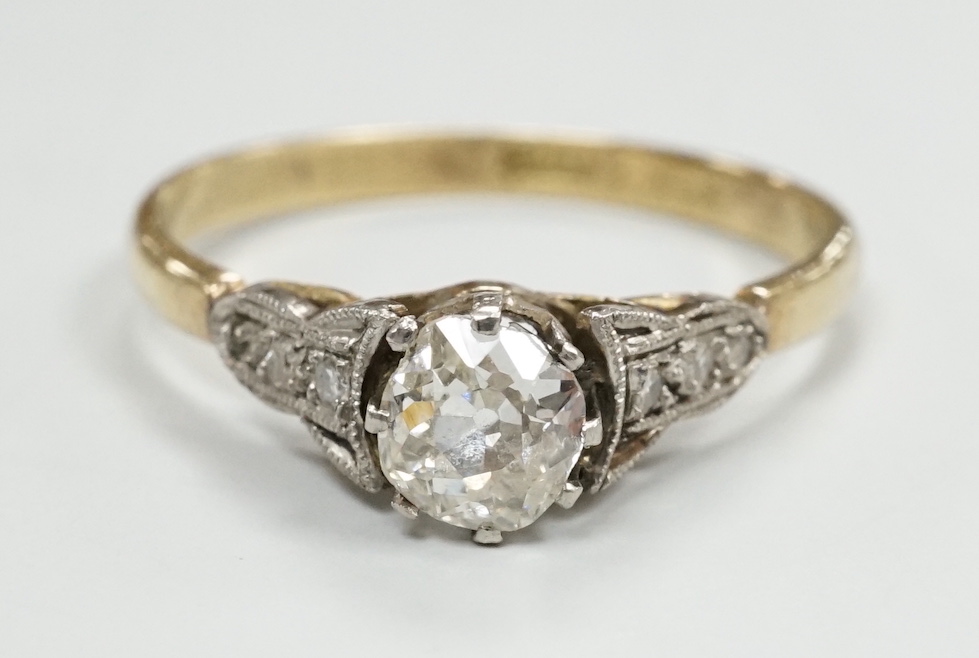 An 18ct and single stone diamond set ring, with diamond set shoulders, size N/O, gross weight 2.2 grams.